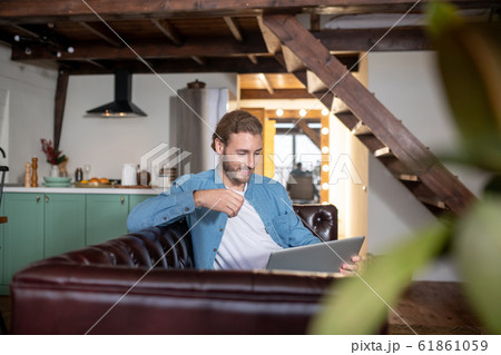 Emotional young man texting with his partner using a laptop 61861059
