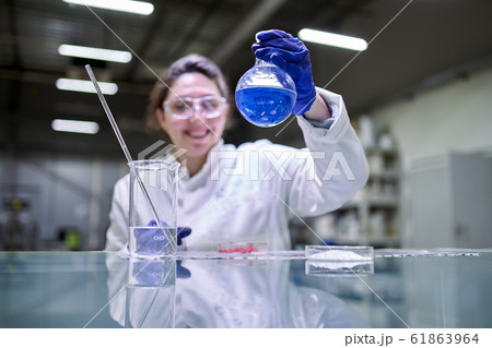 Happy woman laboratory assistant with petri dish in hands 61863964