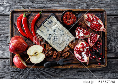 Blue cheese served with garnet, pecan nuts, apples Blue cheese served with garnet, pecan nuts, apples 61867398