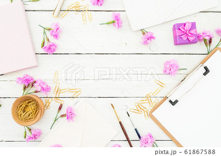 Workspace with clipboard, pink flowers and accessories on white background. Flat lay, top view Workspace with clipboard, pink flowers and accessories on white background. Flat lay, top view 61867588