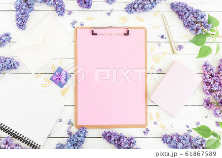 Spring composition with clipboard, envelope, pen and lilac on white background. Flat lay, top view. 61867589