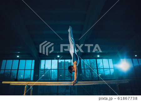 Little male gymnast training in gym, flexible and active 61867738