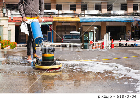 Woman worker using scrubber machine for cleaning polishing concrete floor. Woman worker using scrubber machine for cleaning polishing concrete floor. 61870704