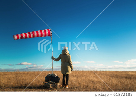 Striped weather vane against blue sky 61872185