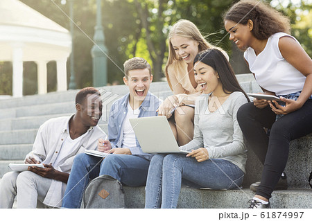 Excited friends checking test results online, using laptop 61874997