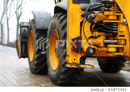 Huge yellow power shovel standing at pavement ready to work 61875382
