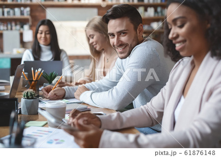 Handsome guy taking notes at group business meeting 61876148