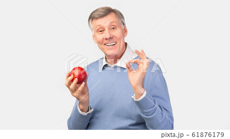 Senior Man Holding Apple Gesturing Okay Over Gray Background, Panorama Senior Man Holding Apple Gesturing Okay Over Gray Background, Panorama 61876179