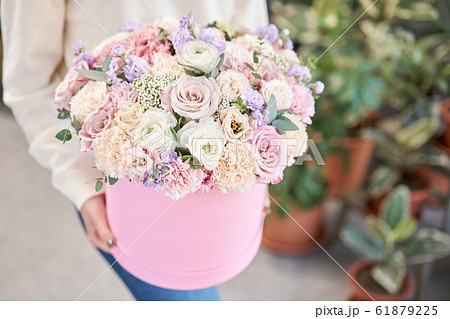 European floral shop. Floral bunch in round box. Bouquet of beautiful Mixed flowers in woman hand. Excellent garden flowers in the arrangement , the work of a professional florist. European floral shop. Floral bunch in round box. Bouquet of beautiful Mixed flowers in woman hand. Excellent garden flowers in the arrangement , the work of a professional florist. 61879225