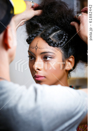 beautiful Latin American model with the assistance of a stylist preparing for a photoshoot 61882442