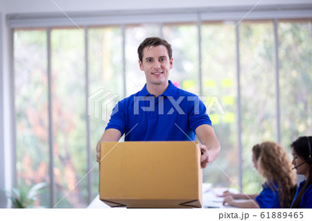 delivery man blue t-shirt holding box in call delivery man blue t-shirt holding box in call 61889465