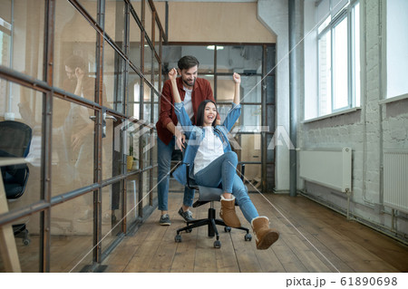 Young girl in jeans feeling happy with her colleague 61890698