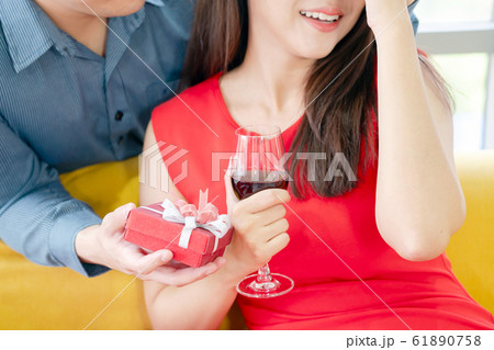 Smiling young man surprising cheerful woman with a 61890758