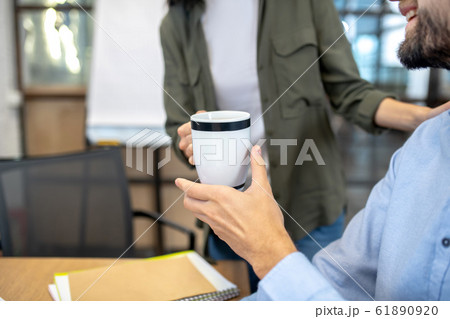 Close up picture of a man holding a cup 61890920