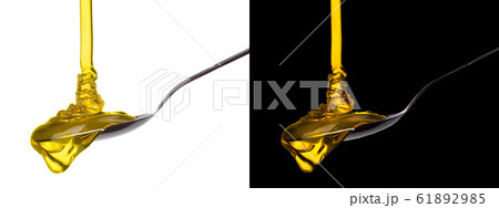Honey on a metal spoon isolated on black and white background 61892985