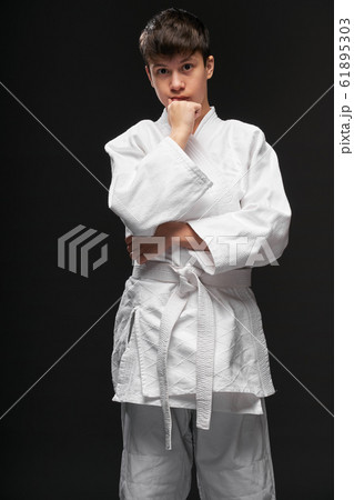 sport concept - a teenager dressed in martial arts 61895303