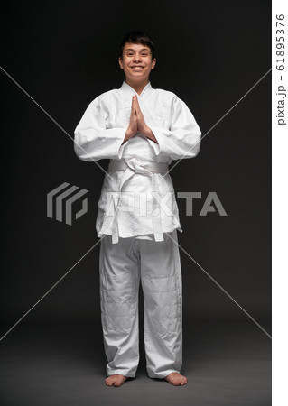 a teenager dressed in martial arts clothing poses a teenager dressed in martial arts clothing poses 61895376