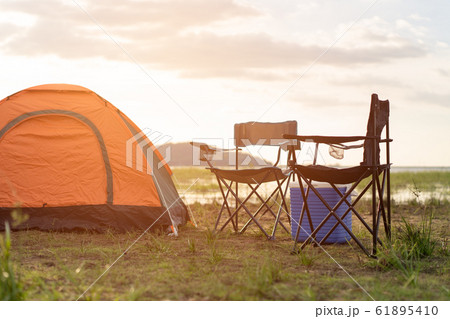 Camping tents, camp tent and chair by the river at sunset in the summer. 61895410