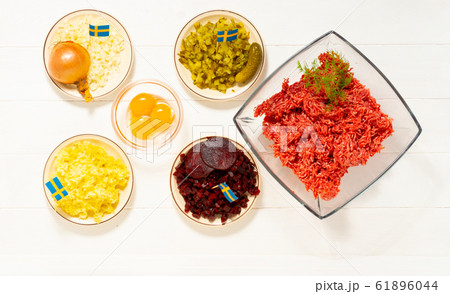 Ingredients for a traditional Swedish dish beef Lindstrom. Freshly minced beef, boiled potato, white chopped onion, pickles, pickled red beets, eggs. Swedish cuisine. Scandinavian Ingredients for a traditional Swedish dish beef Lindstrom. Freshly minced beef, boiled potato, white chopped onion, pickles, pickled red beets, eggs. Swedish cuisine. Scandinavian 61896044