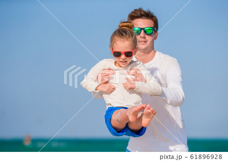 Little girl and happy dad having fun during beach vacation Little girl and happy dad having fun during beach vacation 61896928