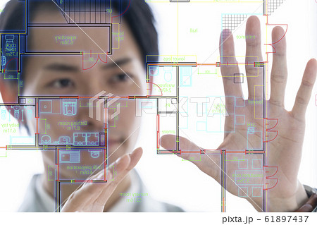 空中ディスプレイに図面投影しプレゼン操作する最先端の一級建築士事務所の男性ビジネスマンの写真素材