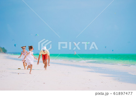 Father and little kids on the beach 61897477
