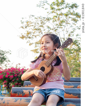 Little asian child girl play the ukulele, in the Little asian child girl play the ukulele, in the 61901840