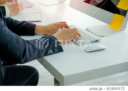 Hands of business man types some data or information to computer 61904372
