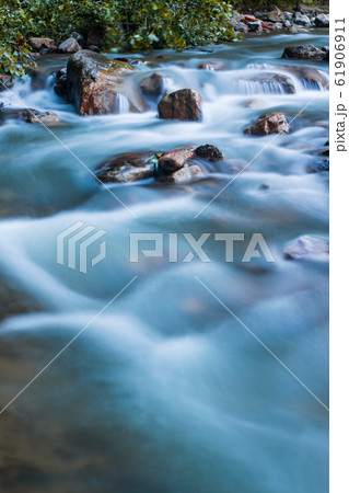 Nature scene of rough, fast flowing river hitting 61906911