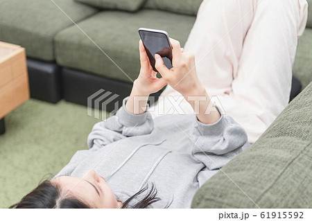 ソファでスマホを操作する女性 ソファでスマホを操作する女性 61915592