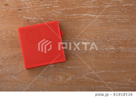 Red wireless speaker on wooden background 61918516