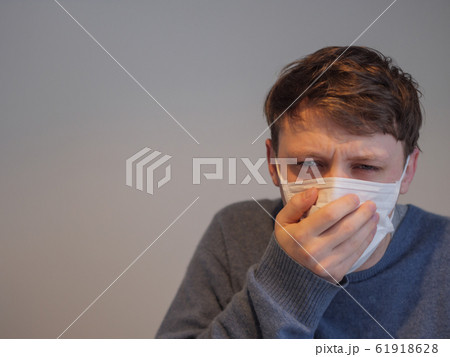 A handsome young man wearing a mask with the flu 61918628
