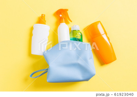 Top view of female cosmetics bag full of suncream 61923040
