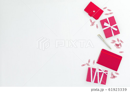 Conceptual frame with notebook, pen and clips on white background. Flat lay. Red composition 61923339