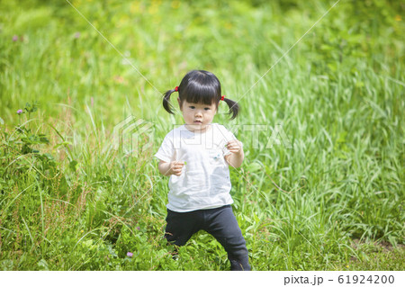 原っぱで遊ぶ女の子の写真素材