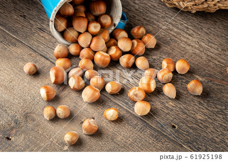 Whole hazelnuts spilled on a wooden background 61925198