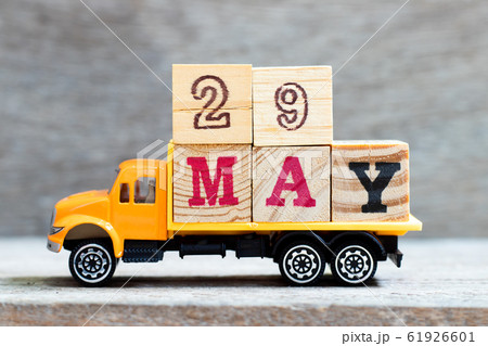 Truck hold letter block in word 29may on wood background  Truck hold letter block in word 29may on wood background  61926601