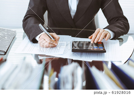 Bookkeeper woman or financial inspector making report, calculating or checking balance, close-up. Business, audit or tax concepts Bookkeeper woman or financial inspector making report, calculating or checking balance, close-up. Business, audit or tax concepts 61928016