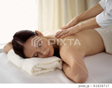 Pretty brunette woman enjoying procedure of back massage in spa salon. Beauty concept Pretty brunette woman enjoying procedure of back massage in spa salon. Beauty concept 61928717