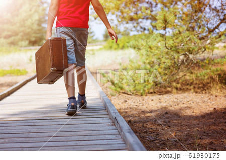 child sitting in car filled with traveling accessories 61930175