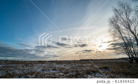 Beautiful setting sun over frozen field 61930415