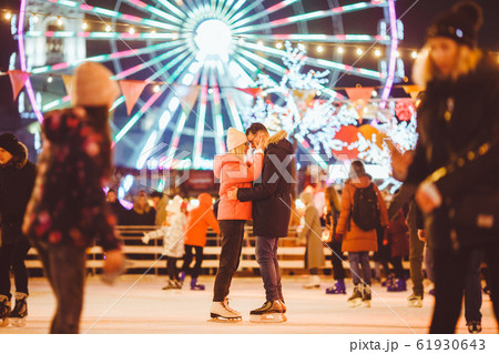 Couple in Love. Romantic Characters for Feast of Saint Valentine. True love. Happy Couple Having Fun at city ice rink in the evening. Happy romantic young couple enjoying together in skating-rink Couple in Love. Romantic Characters for Feast of Saint Valentine. True love. Happy Couple Having Fun at city ice rink in the evening. Happy romantic young couple enjoying together in skating-rink 61930643