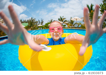 Happy kid with inflatable rubber circle having fun on the beach 61933073