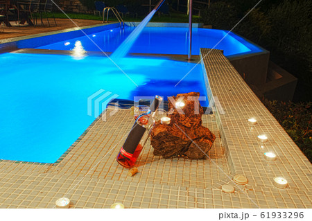 two glasses and bottle of wine at poolside, 61933296