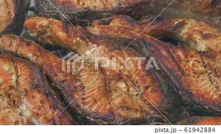 Fried grilled salmon on bbq. Marinade from white sauce and lemon. 61942884