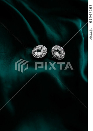 Luxury diamond earrings on dark emerald green Luxury diamond earrings on dark emerald green 61947163