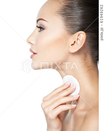 Beautiful woman cleans the neck with cotton swab. Beautiful woman cleans the neck with cotton swab. 61949262