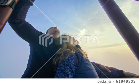 Adventure love couple on hot air balloon watermelon. Man and woman kiss hug love each other. Burner directing flame into envelope. Happy people. 61949505