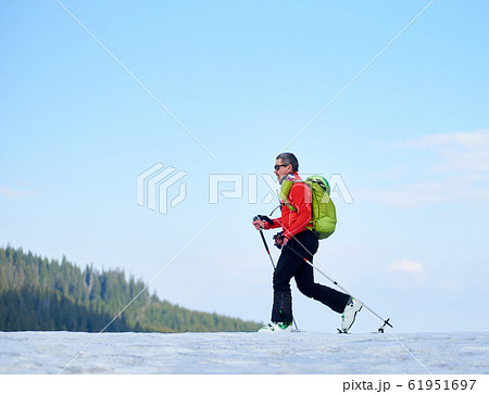 Skier hiker with backpack on skis in deep white snow on background of beautiful winter landscape. 61951697