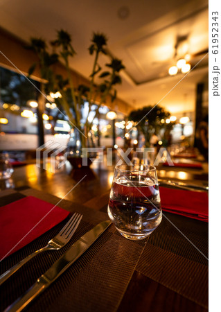 Glass of water on the table with knife and tablecloth inside a restaurant - Restaurant interior with Glass of water on the table with knife and tablecloth inside a restaurant - Restaurant interior with 61952343